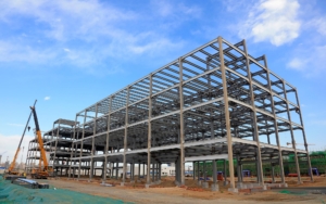 Side view of a large unfinished steel building in the works