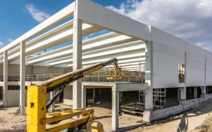 Side view of a large warehouse being built during the day