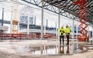 View of two workers at a large scale industrial construction site
